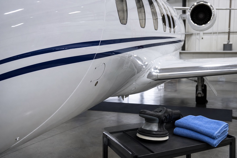 Polished white aircraft paint with professional detailing tools nearby